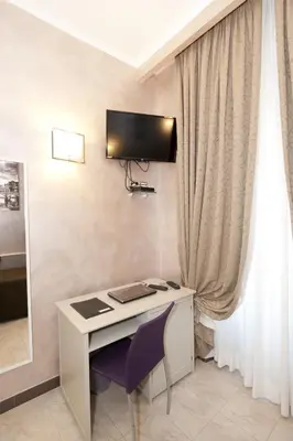 a desk with a computer and a monitor on a wall at Aelius in Rome