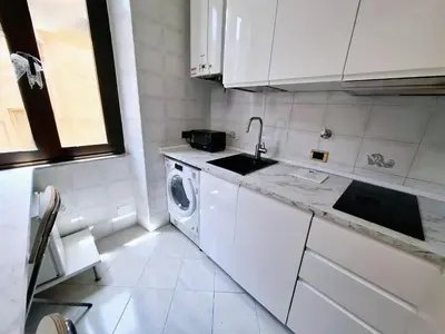 a white kitchen with a sink and a washing machine at Rhome Sweet Rhome in Rome