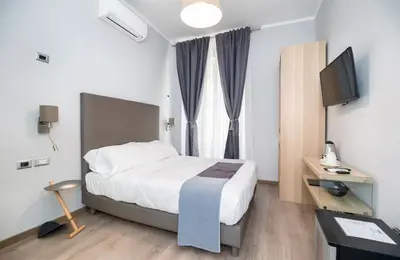 a hotel room with a bed and a television at Clementi 18 Suites Rome in Rome