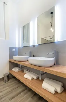 two sinks on a wooden counter in a bathroom at Clementi 18 Suites Rome in Rome