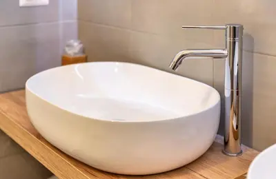 a white sink on a wooden counter with a faucet at Clementi 18 Suites Rome in Rome