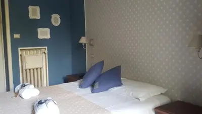 a bedroom with a white bed with blue pillows at La Locanda dell'Angelo in Rome