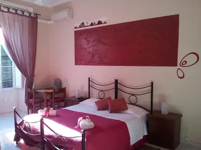 a bedroom with a bed with a red blanket at La Locanda dell'Angelo in Rome