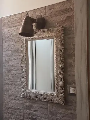 a mirror on a wall with a light and a lamp at La Locanda dell'Angelo in Rome