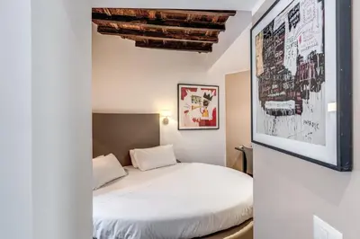 a bedroom with a white bed in a room at Reginella Suites in Rome