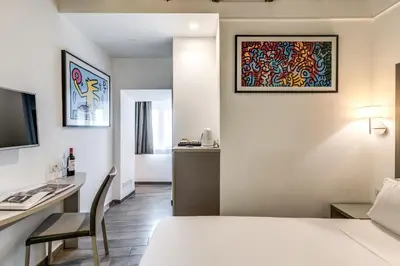 a hotel room with a bed and a table and a desk at Reginella Suites in Rome