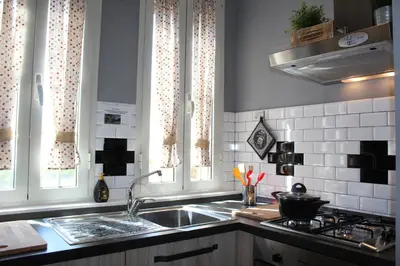 a kitchen with a sink and a stove and windows at Terrazza 29 Holiday Home in Rome