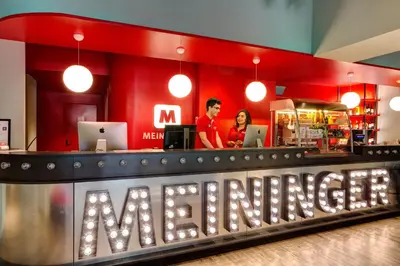 a man and woman standing at the counter of a restaurant at MEININGER Roma Termini in Rome