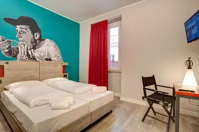 a bedroom with a mural of a man with a hat at MEININGER Roma Termini in Rome