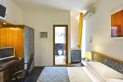 a bedroom with a bed and a desk with a computer at Hotel Marcantonio in Rome