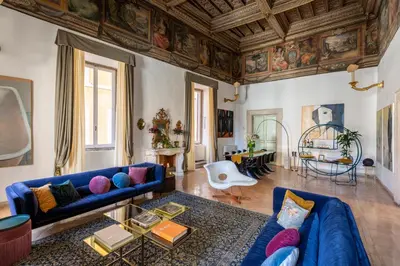 a living room with a blue couch and a wooden ceiling at Experience Collection by ROMAC - Costaguti Experience in Rome