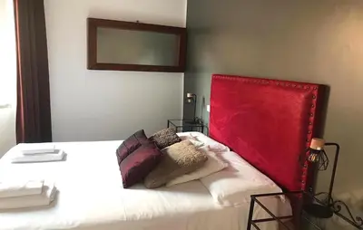 a bedroom with a bed with a red headboard at DormiRoma - Cedro 21 Apartments in Rome