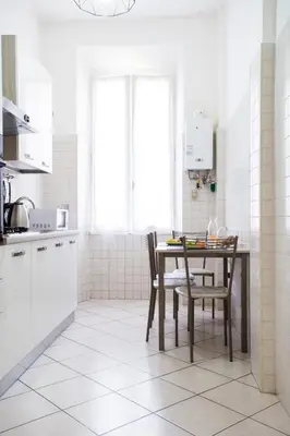 a kitchen with a table and chairs in a room at Enjoy Ponte Lungo in Rome