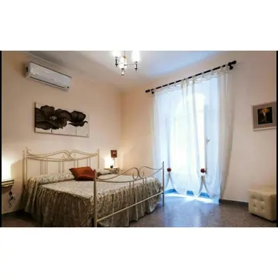 a bedroom with a bed and a large window at Domus Ines Roma San pietro in Rome
