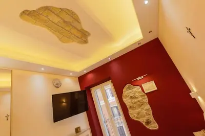 a room with a ceiling with a tv and footprints on the wall at Spartacus Inn Apartment in Rome