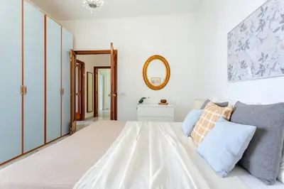 a white bedroom with a bed and a mirror at Perfetto per Famiglie Appartamento Accogliente e Spazioso a 15 min dalla Metro in Rome