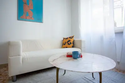 a living room with a white couch and a coffee table at Perfetto per Famiglie Appartamento Accogliente e Spazioso a 15 min dalla Metro in Rome