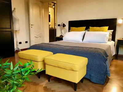 a bedroom with a large bed and two yellow chairs at Sweethome Crispi in Rome