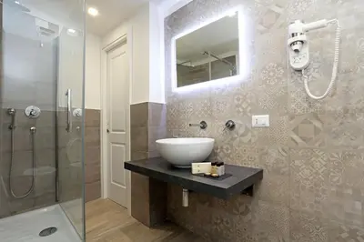 a bathroom with a sink and a glass shower at Capricci Romani in Rome