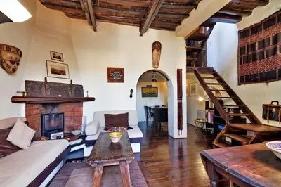 a living room with a couch and a fireplace at Vicolo del Cinque Penthouse | Romeloft in Rome