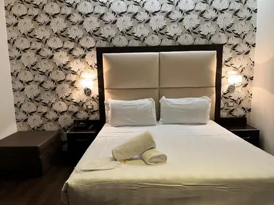 a bedroom with a large white bed with a headboard at Catone District Hotel in Rome