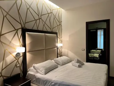 a bedroom with a bed with two pillows and a mirror at Catone District Hotel in Rome
