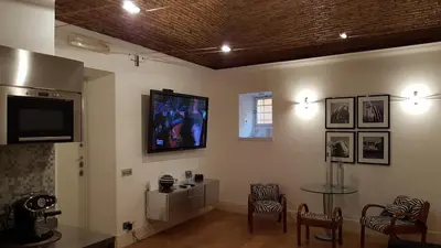 a living room with a tv and a table and chairs at Rose Roma in Rome