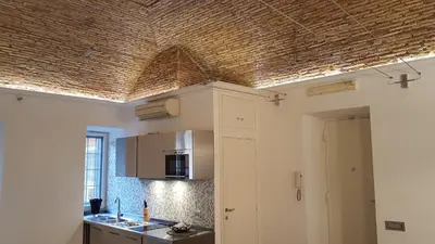 a kitchen with a ceiling with a straw roof at Rose Roma in Rome