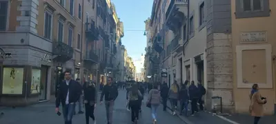 a group of people walking down a city street at Rose Roma in Rome