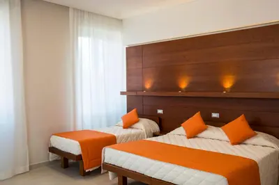 a hotel room with two beds with orange pillows at Villa Angelina in Rome