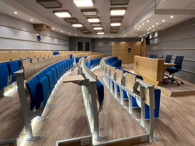 an empty lecture hall with blue chairs and tables at Villa Angelina in Rome