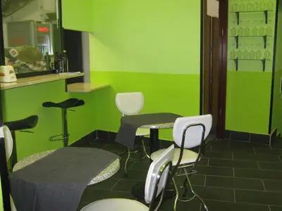 a green room with chairs and a table and a counter at Hotel Ferraro in Rome
