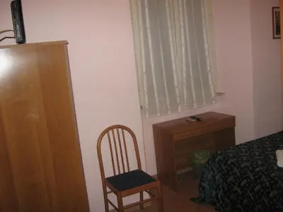 a bedroom with a bed and a dresser and a chair at Hotel Ferraro in Rome