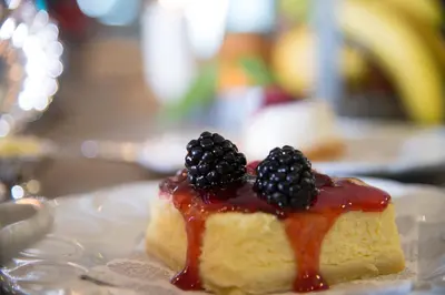 a piece of cake with blackberries on top on a plate at Hotel Villa Linneo in Rome