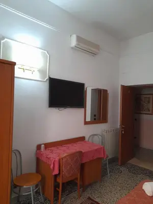 a room with a table and a television on the wall at Incantoromano guest house in Rome