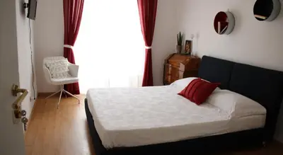 a bedroom with a bed with a red pillow and a window at Incantoromano guest house in Rome