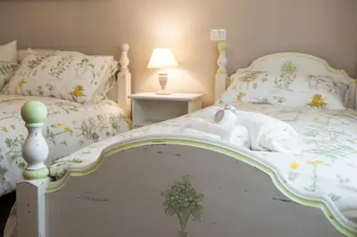 a white bed with a cat laying on it at Magnolia St.Peter's Suites in Rome