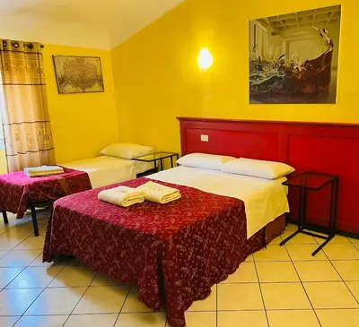 two beds in a room with yellow walls at Fanti Rooms in Rome