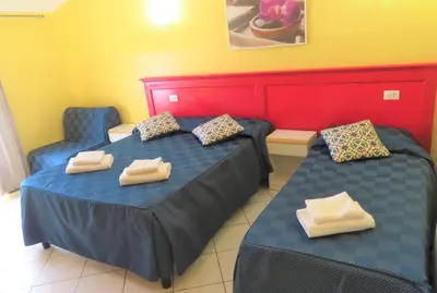 a room with two beds and two chairs at Fanti Rooms in Rome