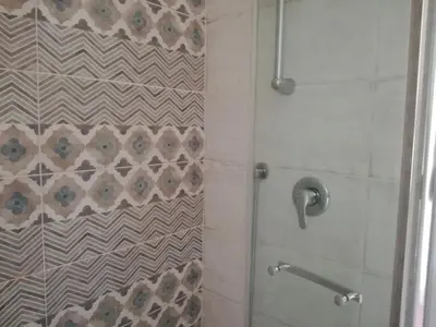 a bathroom with a shower with a glass door at La casa di Alice in Rome