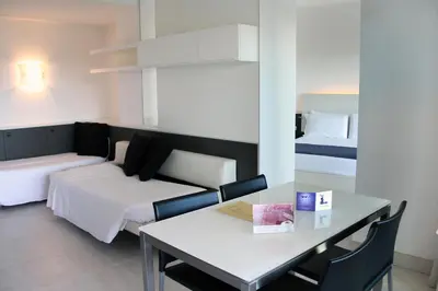a room with a bed and a table and a bed and a couch at Lungotevere Suite in Rome
