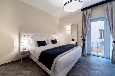 a bedroom with a large bed and a large window at Foro Romano Luxury Suites in Rome