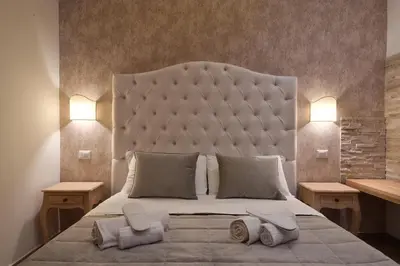 a bedroom with a large bed with a large headboard at Veneto Suite Rome in Rome