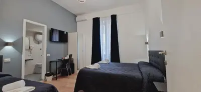 a hotel room with a bed and a bathroom at Piumith Guest House in Rome