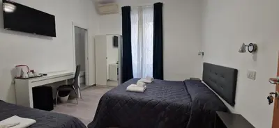 a hotel room with a bed with a teddy bear on it at Piumith Guest House in Rome