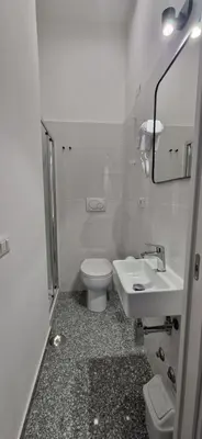 a white bathroom with a toilet and a sink at Piumith Guest House in Rome