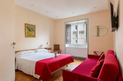 a bedroom with a large bed and a red couch at Martina House in Rome