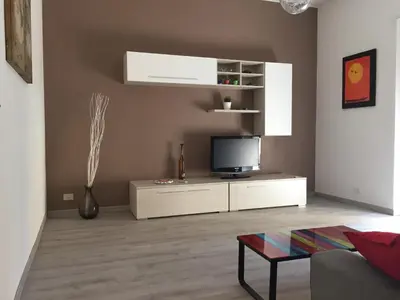 a living room with a tv on a white cabinet at BenS'Houses - Villa Pamphili apartment in Rome