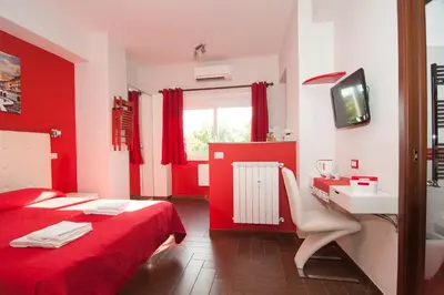 a red room with a bed and a desk and a television at World Wide Bed - Prenestino in Rome