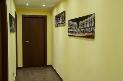 a hallway with two pictures on the wall and a door at World Wide Bed - Prenestino in Rome